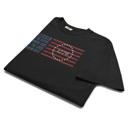 Folded black Psalm 33:12 men's Christian shirt with patriotic American Flag graphic.