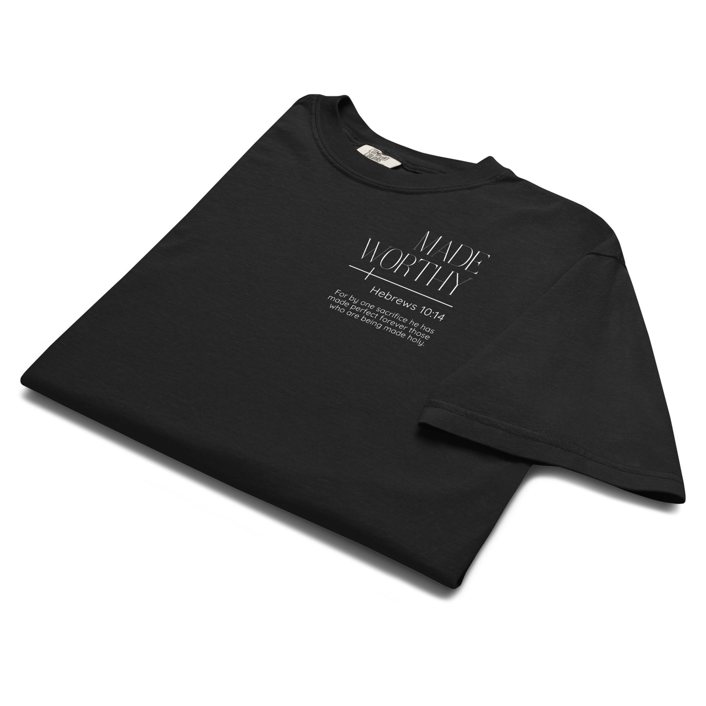 Folded black Made Worthy Hebrews 10:14 Christian tee showing the white left chest Scripture graphic.