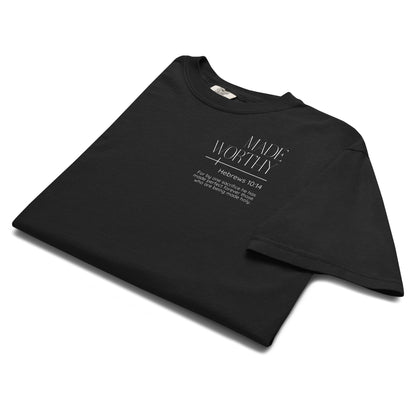 Folded black Made Worthy Hebrews 10:14 Christian tee showing the white left chest Scripture graphic.