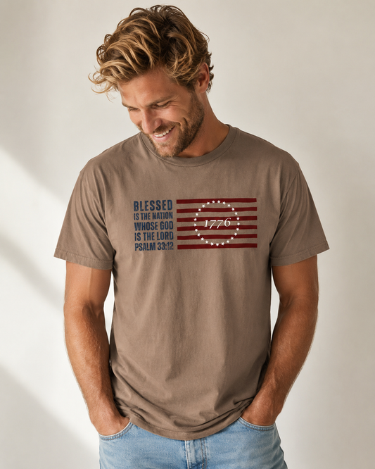Joyful male model wearing the Blessed Is the Nation Psalm 33:12 Christian patriotic T-shirt in espresso.