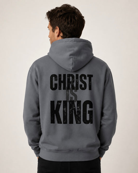 Male model wearing a denim Christ Is King men’s hoodie, shown from the back with bold black Christian typography.