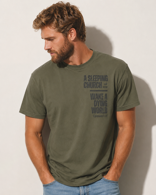 Man wearing a sage green Ephesians 5:14 Christian T-shirt featuring the words “A sleeping church will never wake a dying world.”