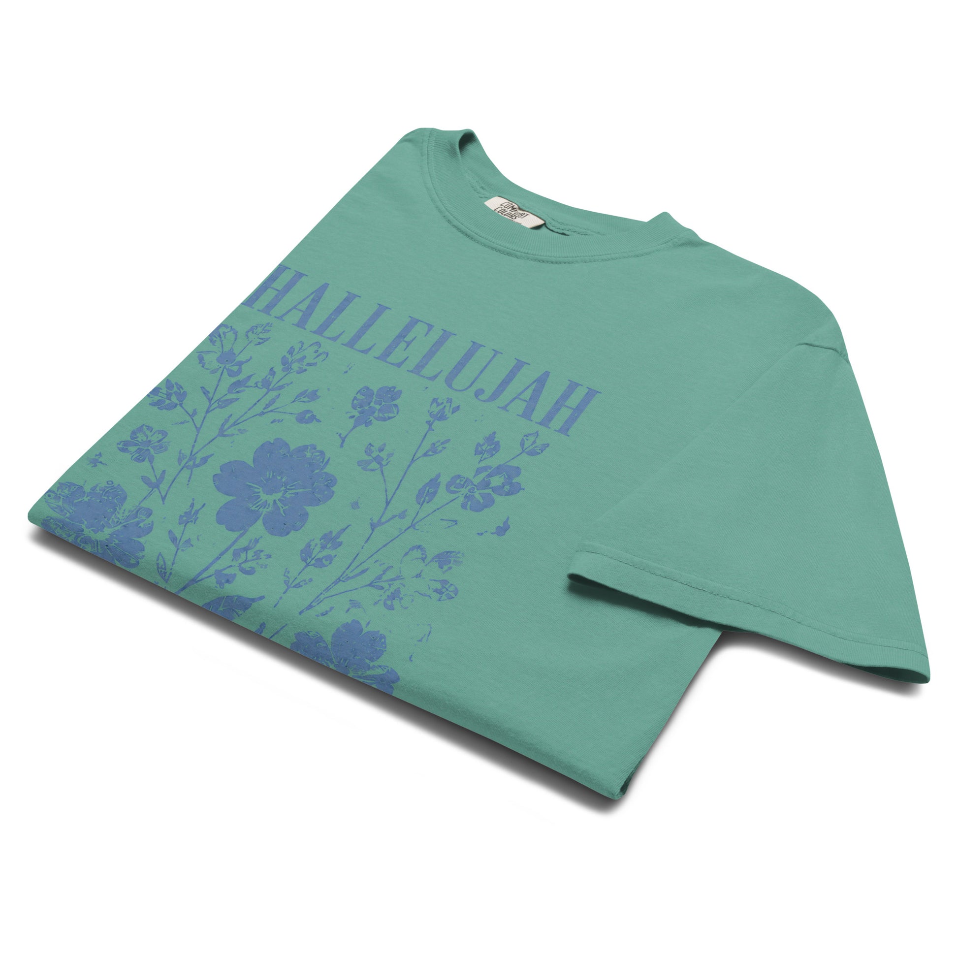 Angled close-up of the seafoam Hallelujah T-shirt with distressed blue wildflower artwork