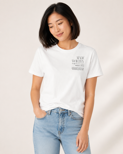 Woman looking down wearing a white Made Worthy Christian T-shirt inspired by Hebrews 10:14 in an off-white studio