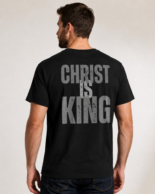Male model wearing a black Christ Is King Christian T-shirt featuring distressed gray lettering on the back.