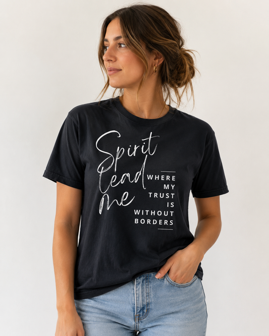 Woman wearing a black “Spirit Lead Me Where My Trust Is Without Borders” Christian T-shirt against an off-white studio background