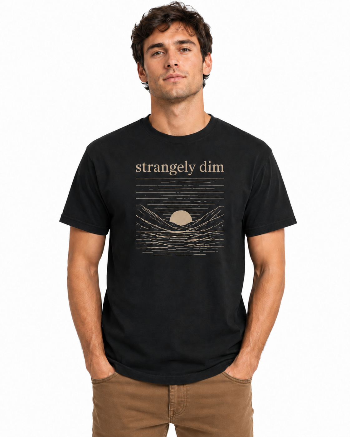 Male model wearing a black Strangely Dim Christian graphic T-shirt with brown pants on a white background