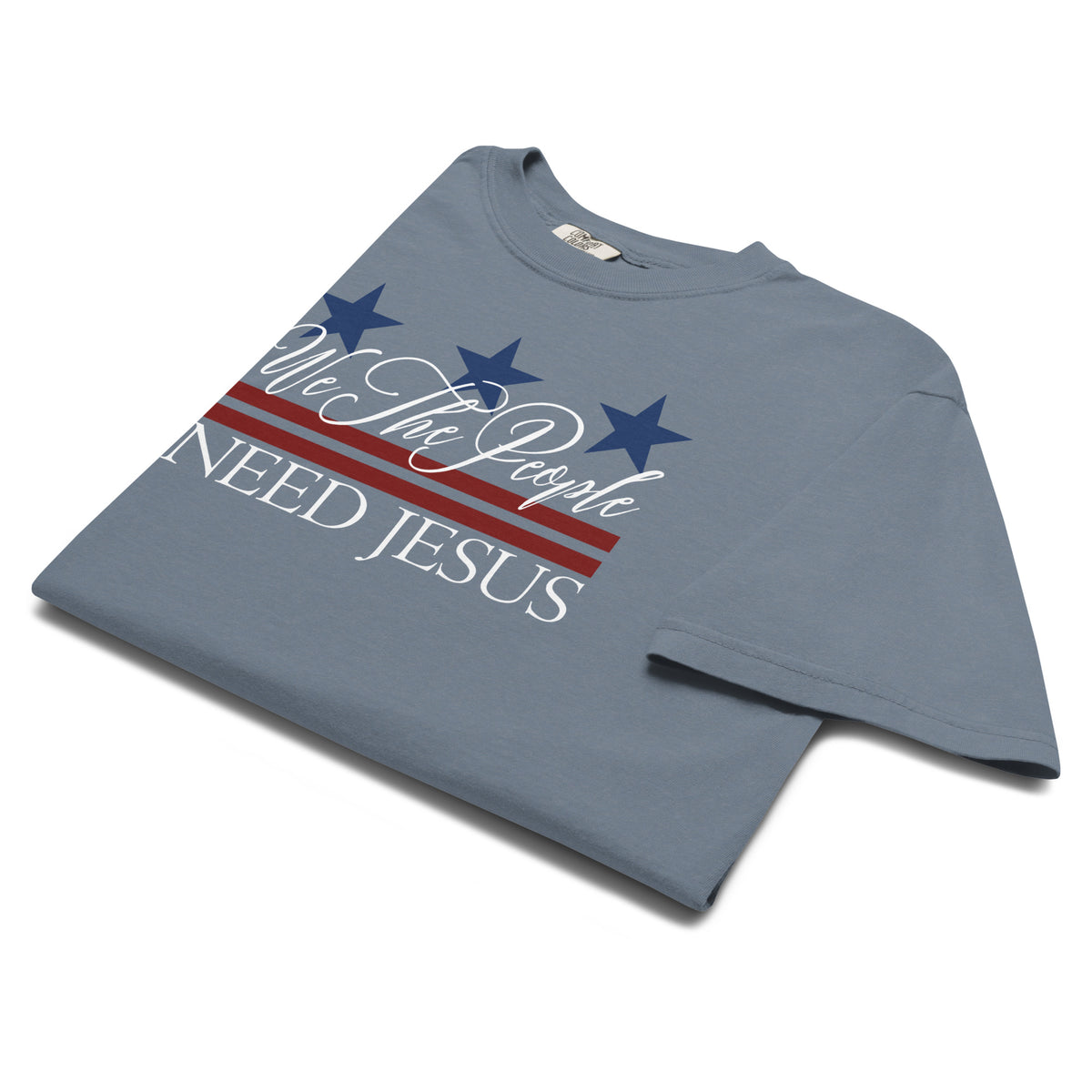 Angled view of the Blue Jean We the People Need Jesus women’s patriotic Christian T-shirt.