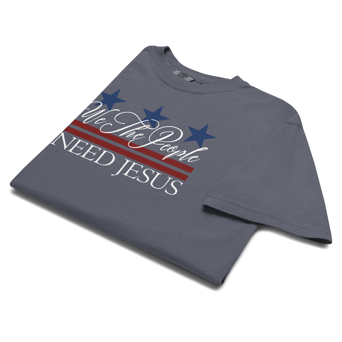 Angled close-up of the We the People Need Jesus graphic on a Denim blue T-shirt.