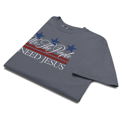 Angled close-up of the We the People Need Jesus graphic on a Denim blue T-shirt.