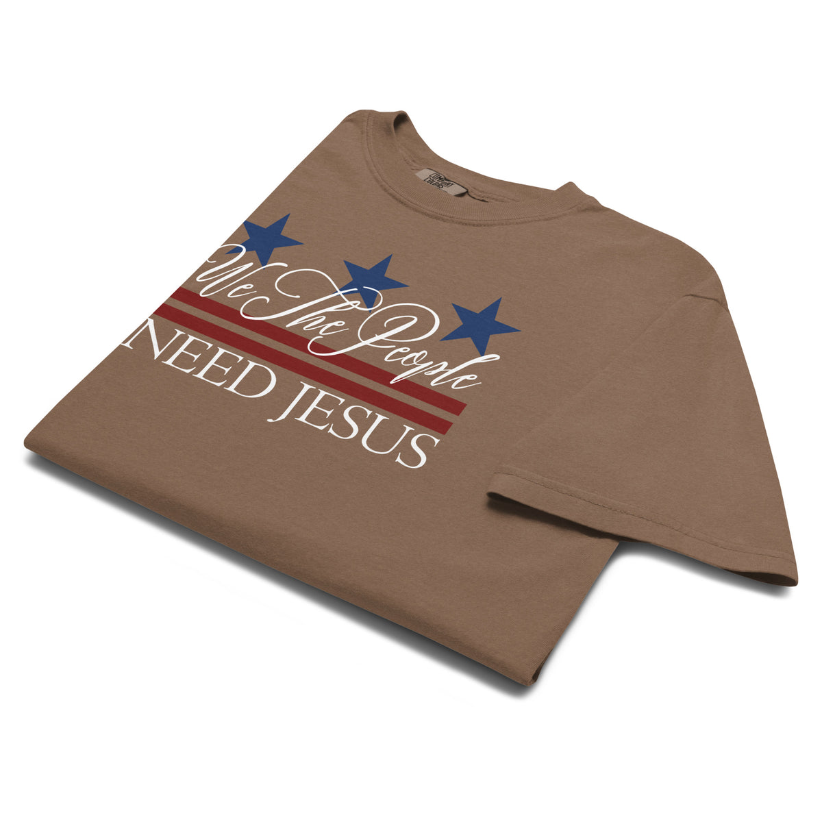 Angled close-up of the We the People Need Jesus graphic on an Espresso brown T-shirt.